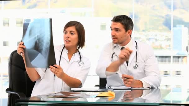 Dois médicos a falar de um exame. — Vídeo de Stock