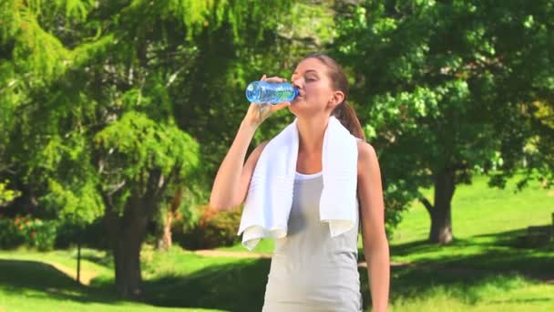 Женщина пьет воду после занятий спортом — стоковое видео