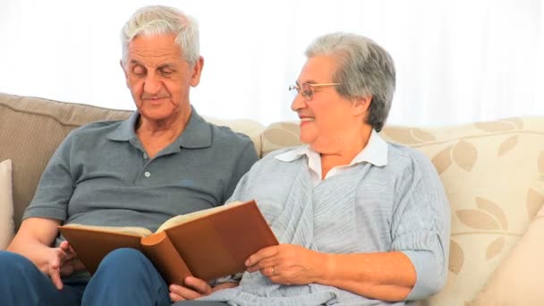 Coppia guardando il loro album di foto — Video Stock