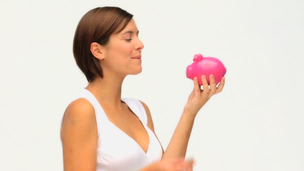 Brunetka, oszczędzając pieniądze w piggy bank — Wideo stockowe