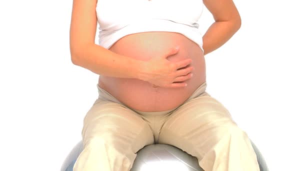 Pregnant woman playing with baby shoes on her belly — Stock Video