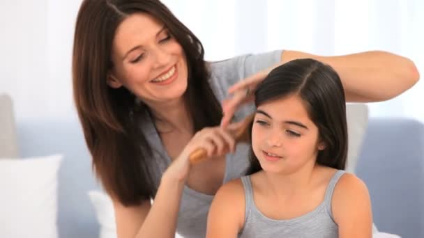 Brunette mother fixing hair of her daughter — Stock Video