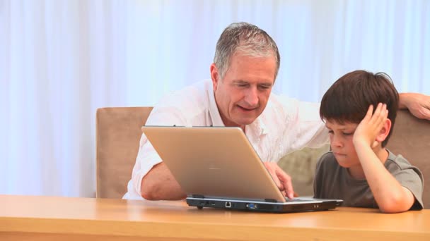 Grandfather using a laptop with his grandson — Stock Video