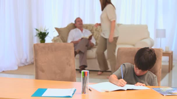 Mooie donkerharige jongen doen zijn homeworks — Stockvideo