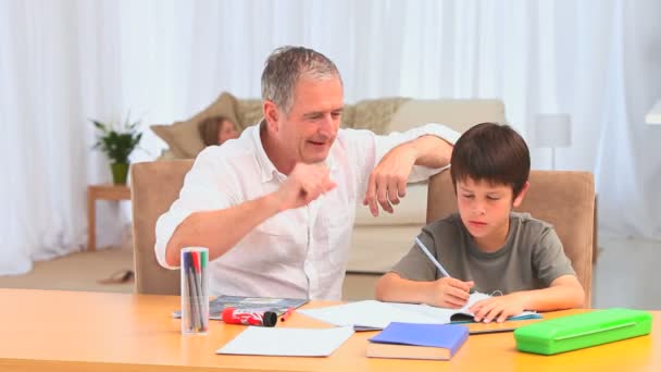 Donkerharige jongetje doen homeworks — Stockvideo