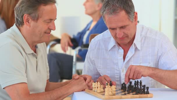 Ältere Freunde spielen Schach — Stockvideo