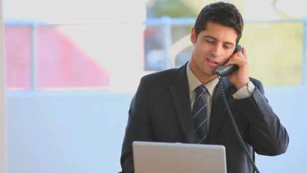 Zakenman dressing in een pak spreken op de telefoon — Stockvideo