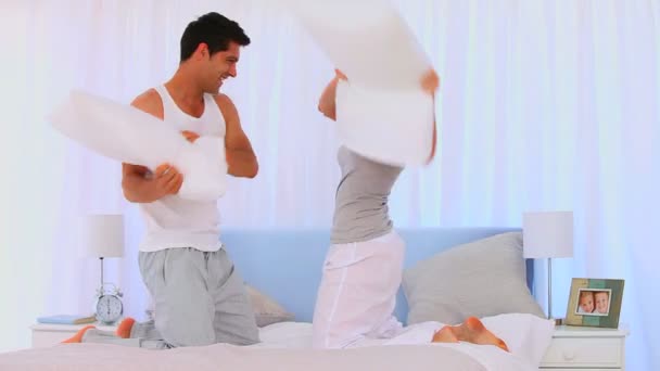 Pareja feliz teniendo una pelea de almohadas — Vídeos de Stock