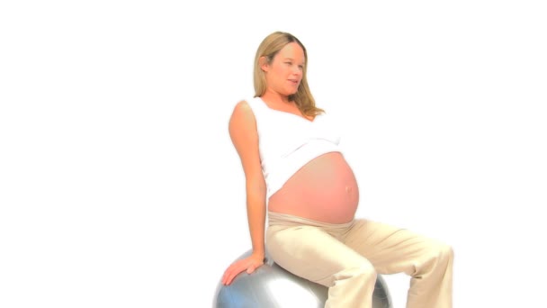 Mujer embarazada haciendo streches contra un fondo blanco — Vídeos de Stock