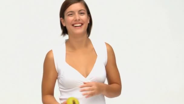 Симпатична брюнетка їсть яблуко — стокове відео