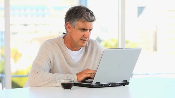 Casual μέσης ηλικίας άνθρωπος που εργάζονται σε ένα φορητό υπολογιστή — Αρχείο Βίντεο
