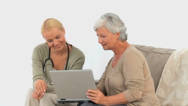 Eine Patientin zeigt ihrer Krankenschwester etwas auf ihrem Laptop — Stockvideo