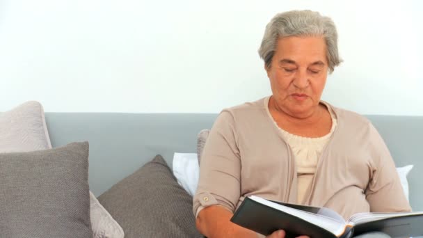 Mujer madura mirando su álbum de fotos — Vídeo de stock