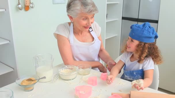 Söta curly-haired girl bakning med hennes mormor — Stockvideo