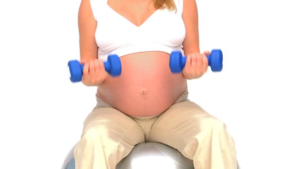 Pregnant woman doing exercises against a white background — Stock Video