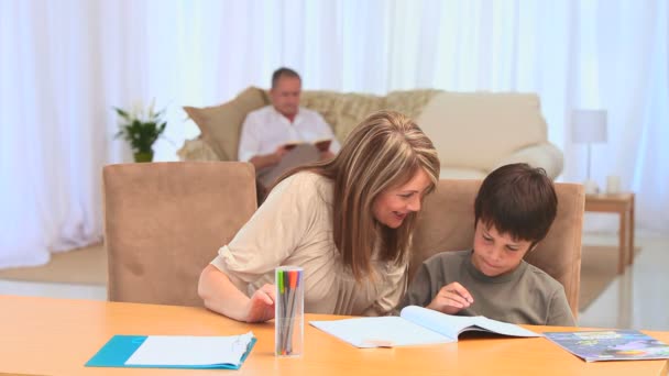 Een jongen doen zijn homeworks met zijn grootmoeder — Stockvideo