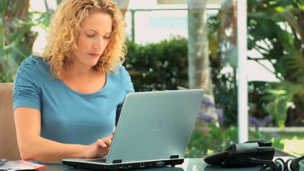 Curly mulher cabeludo trabalhando em um laptop — Vídeo de Stock