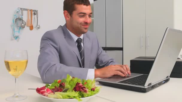 Бізнесмен працює на ноутбуці під час обіду — стокове відео
