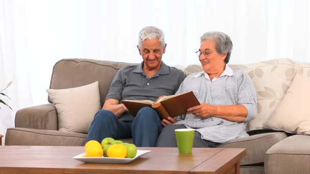 Senior couple looking at their photo album — Stock Video