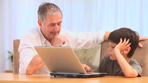 Ein Junge und sein Großvater mit einem Laptop — Stockvideo