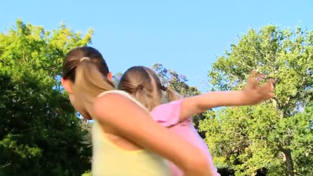 Donna dando a sua figlia un maialino indietro — Video Stock