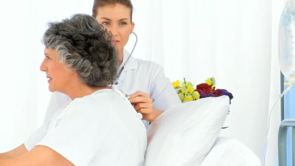 Enfermera tomando el latido de su paciente maduro — Vídeo de stock