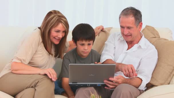 Familia jugando un juego en un ordenador portátil — Vídeos de Stock