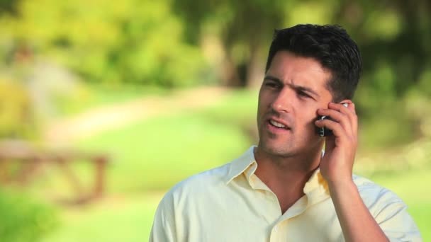 Relaxed man talking on a phone outdoors — Stock Video