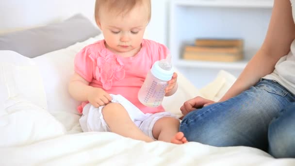 Toddler playing with her baby bottle — Stock Video