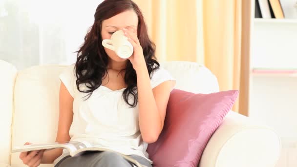 阅读一本杂志时喝茶的女人 — 图库视频影像