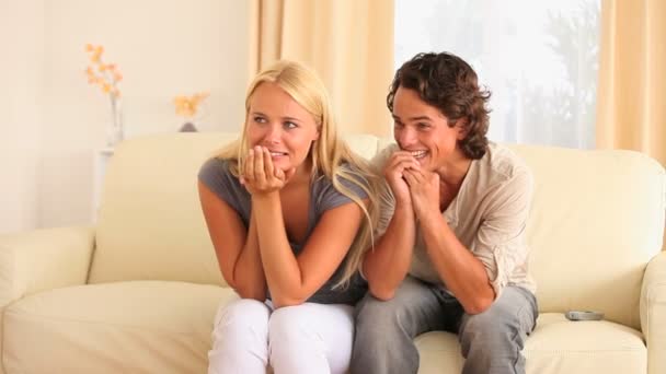 Emocionado casal sentado em um sofá — Vídeo de Stock