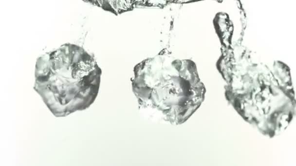 Ледяные кубики брызгаются в воду в супер медленном режиме — стоковое видео