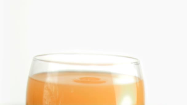 Капли апельсинового сока падают в замедленной съемке — стоковое видео