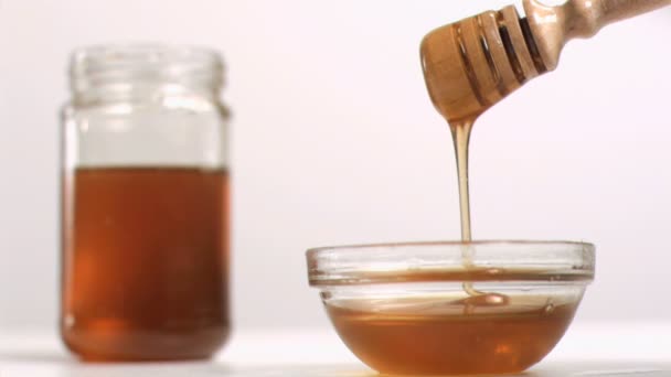 Miel fluyendo en cámara súper lenta desde una cuchara — Vídeo de stock