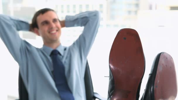 Gelukkig zakenman met zijn voeten op een bureau — Stockvideo