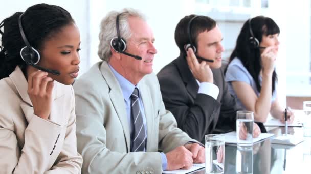 Equipo de negocios alegre usando auriculares — Vídeos de Stock