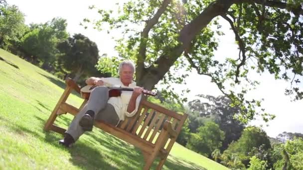 Hombre jubilado tocando la guitarra se levanta — Vídeos de Stock