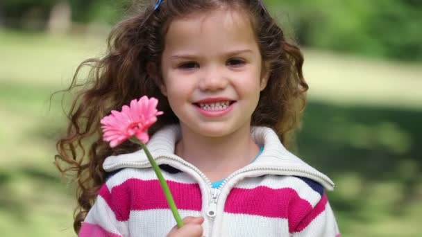 Маленькая девочка показывает розовый цветок — стоковое видео