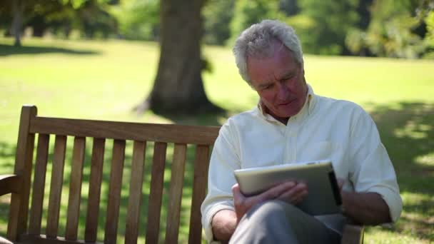 Пенсионер использует электронную книгу — стоковое видео