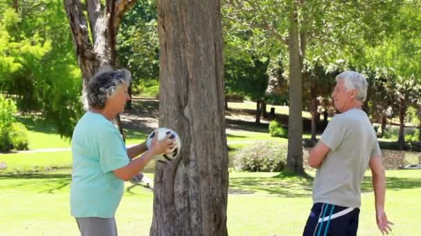 Smiling mature couple playing with a soccer ball — Stock Video