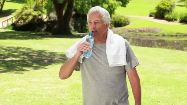 Счастливый зрелый мужчина пьет воду после занятий спортом — стоковое видео