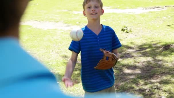 Lachende jongen speelt met een honkbal met zijn vader — Stockvideo