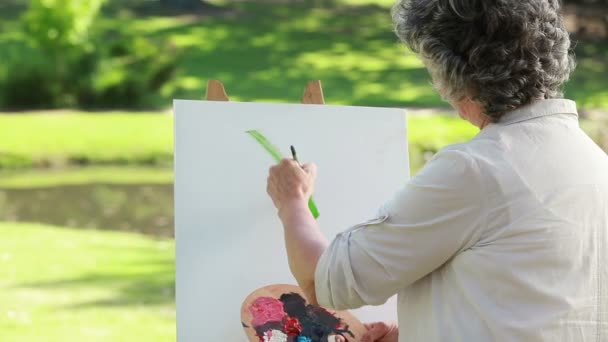 Gelukkig volwassen vrouw tekenen op een doek — Stockvideo