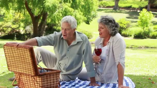 Smiling mature man showing strawberries to his wife — Stock Video