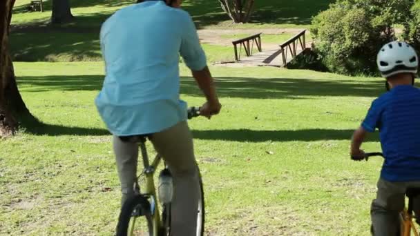 Pai e filho passam o tempo juntos enquanto andam de bicicleta — Vídeo de Stock
