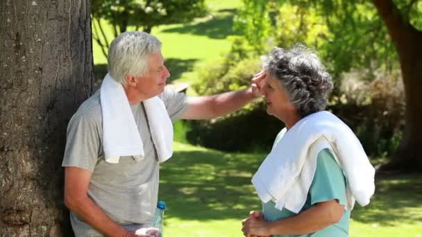 Ouder paar vegen hun voorhoofd met handdoeken — Stockvideo