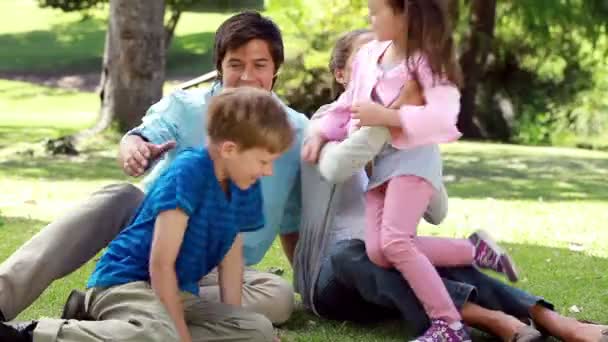 Happy children coming then sitting with their parents — Stock Video