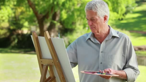 Homme mûr souriant tenant une palette de peinture — Video