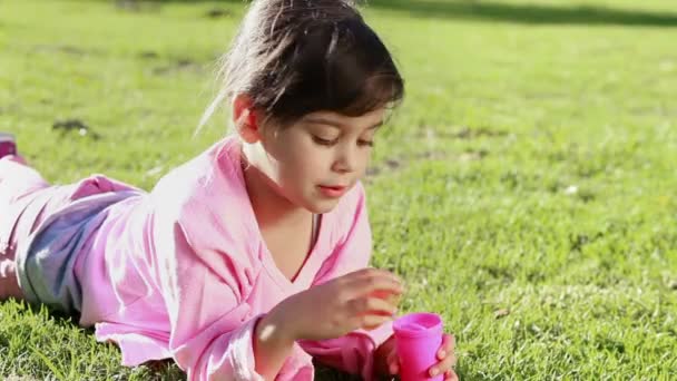 Menina feliz fazendo bolhas com uma varinha de bolha — Vídeo de Stock