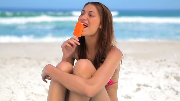 Lachende vrouw eten een heerlijke popsicle — Stockvideo
